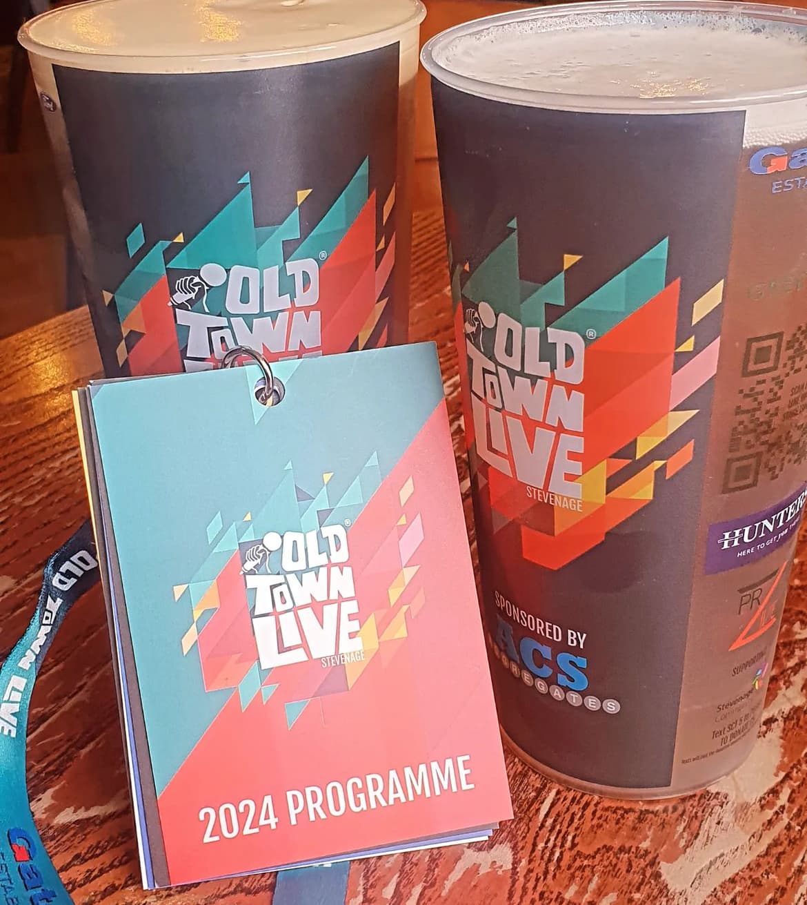Matching event artwork printed on reusable cups and a programme
